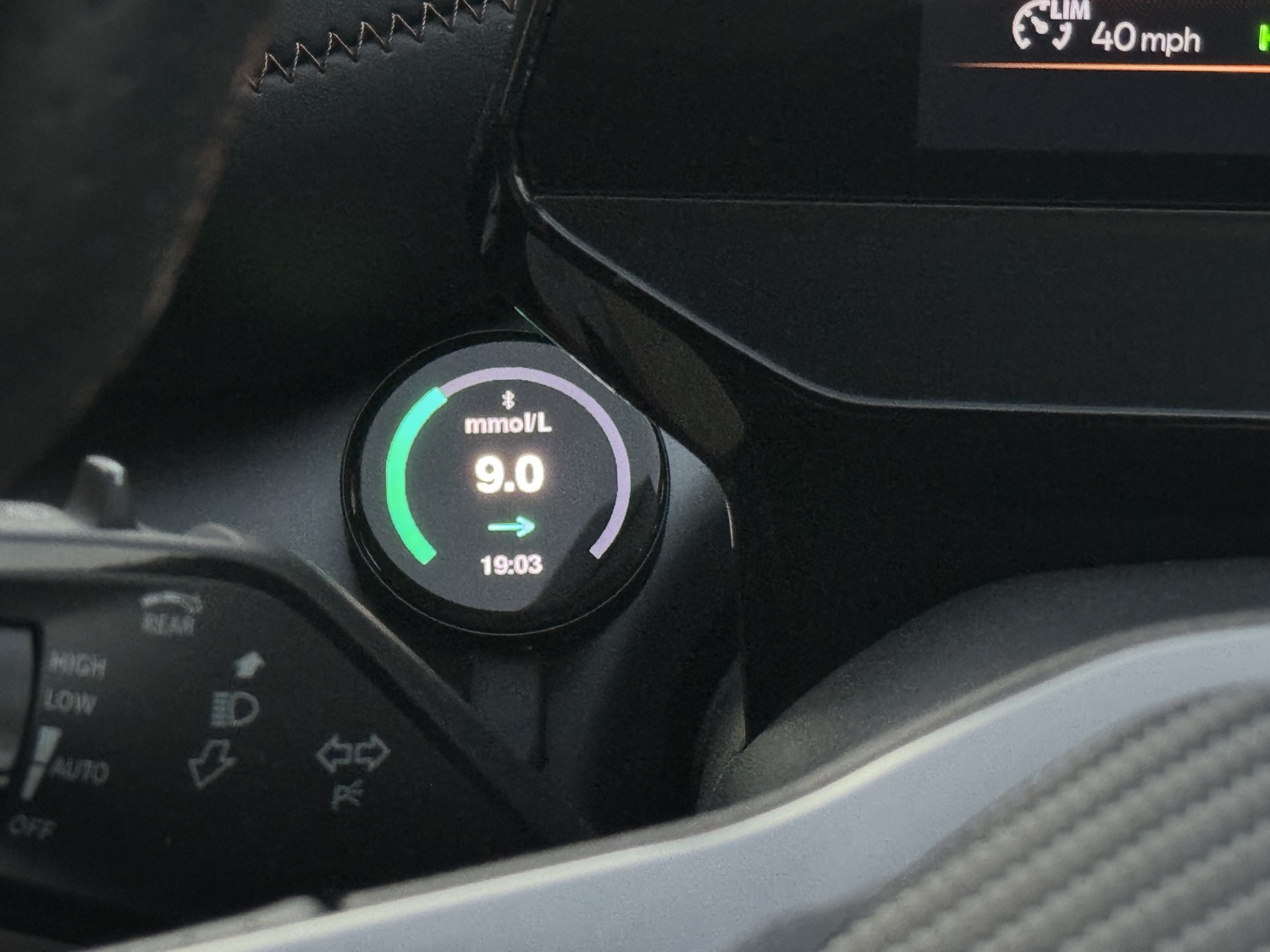 Close-up of the GlucoDial display showing a large 9.0 reading in white with a green and lilac ring and a steady-trend arrow.