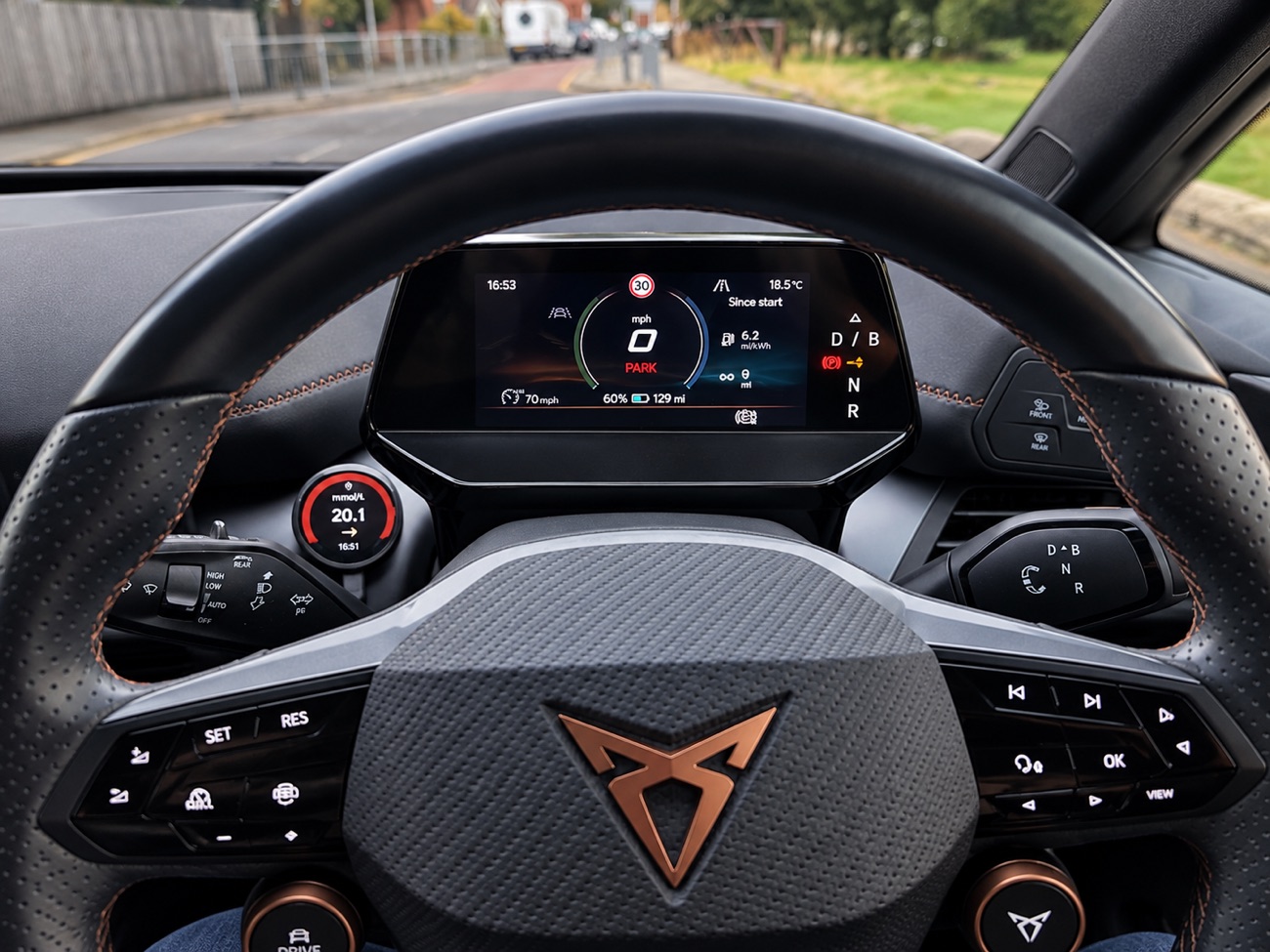 GlucoDial showing 20.1 mmol per litre with a red ring, mounted by a Cupra steering wheel.